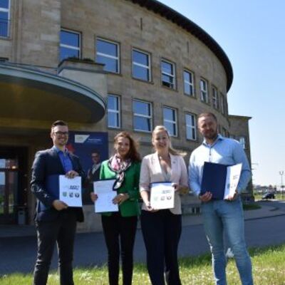 Matthias Egert (Bürgermeister der Stadt Zörbig), Bitterfeld-Wolfens Bürgermeisterin Heike Krauel, Steffi Syska (Bürgermeisterin der Stadt Sandersdorf-Brehna) und OB-Referent Marcel Urban mit den unterzeichneten Vereinbarungen (v. l.)