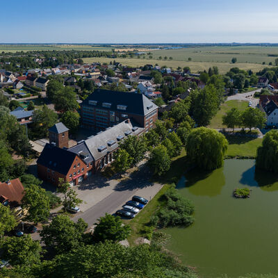 Bild vergrößern: Der Roitzscher Teich mit Schule mit Teich und Feuerwehr - Luftaufnahme