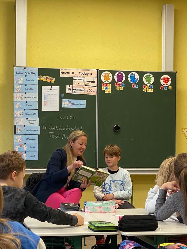 Bild vergrößern: Steffi Syska liest gemeinsam mit einem  Jungen in der 4. Klasse in der Grundschule  Am Wldchen in Sandersdorf.
