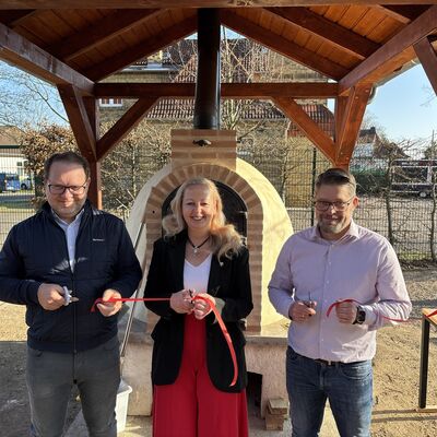 Bild vergrößern: Der ehemalige Ortsbürgermeister Michael Aermes, Bürgermeisterin Steffi Syska und Dr. Eric Römbach durchschneiden das symbolische Band.
