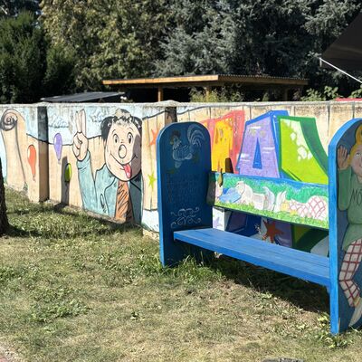 Bild vergr&ouml;&szlig;ern: Hier sieht man eine bunte Bank. Vor den eben genannten bemalten B&auml;nken.