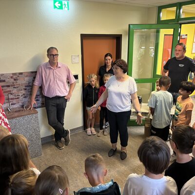 Bild vergrößern: Frau Johanssen erklärt den Kindern wie der Brunnen funktioniert.