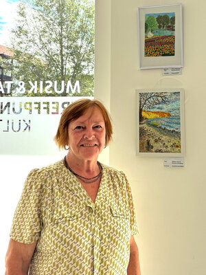 Bild vergrößern: Petra Hitschler vor Bildern ihrer Ausstellung im Mehrgenerationentreff Sandersdorf