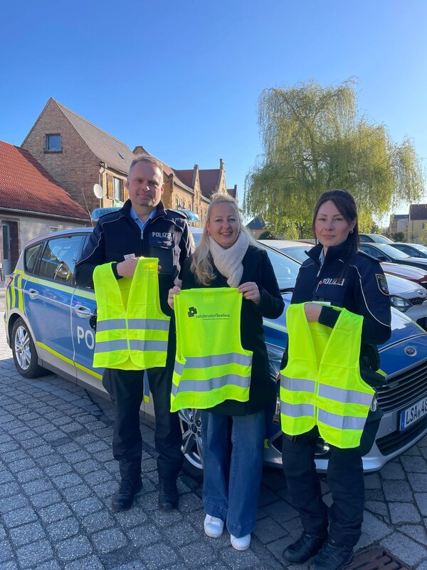 Steffi Syska &uuml;berreicht die Warnwesten an die &Ouml;rtlichen Polizeibeamten.
